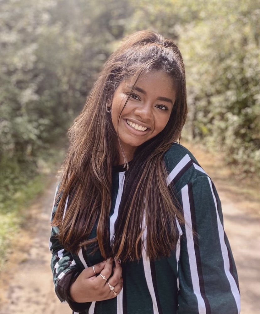 Young Latino woman with long dark hair smiling at camera