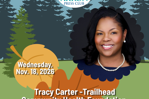 Professional headshot of Tracy Carter, president and CEO of Trailhead Community Health Foundation, smiling against a dark background. She wears a navy blue dress, pearl necklace and pearl earrings.