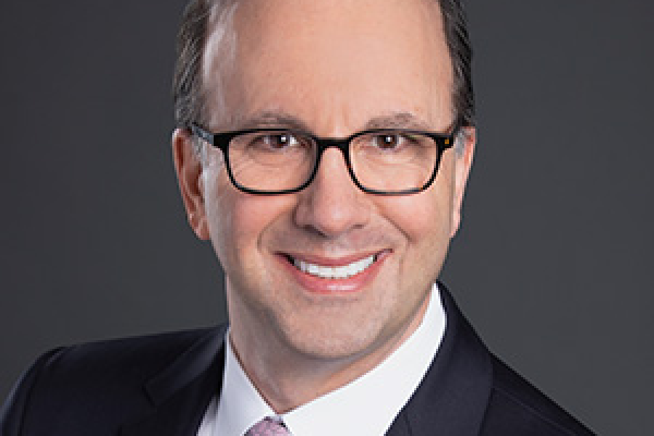 caucasian man wearing glasses and suit and smiling